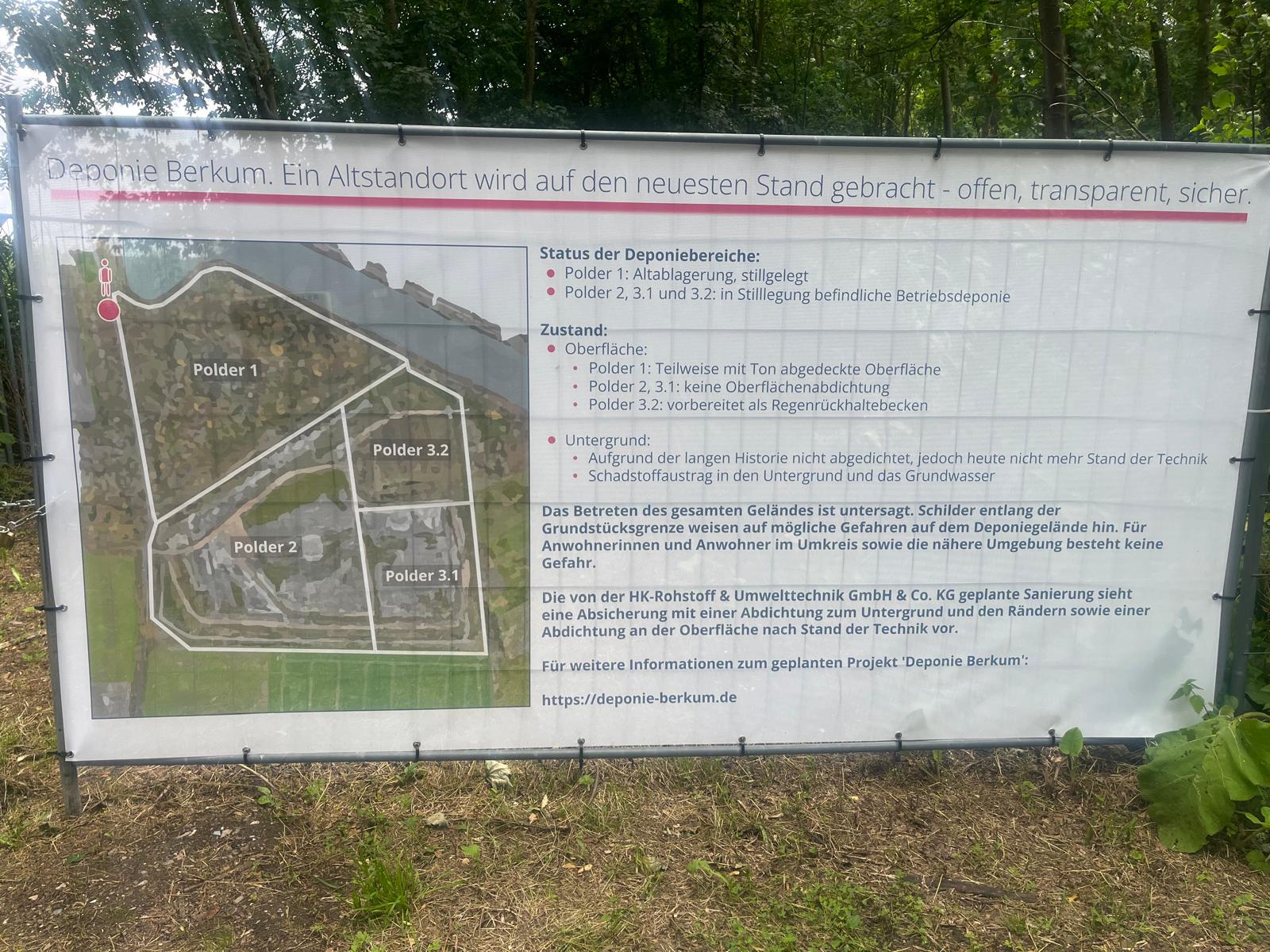 Banner des Betreibers am Zaun der Deponie Berkum. Überschrift: „Deponie Berkum. Ein Altstandort wird auf den neuesten Stand gebracht – offen, transparent, sicher.“ Darunter eine Karte der Polder, Angaben zum Zustand von Oberfläche und Untergrund sowie der Hinweis auf die Webseite deponie-berkum.de. Die geplante neue DK-II-Deponie mit 35 Meter hoher Aufschüttung wird nicht erwähnt.